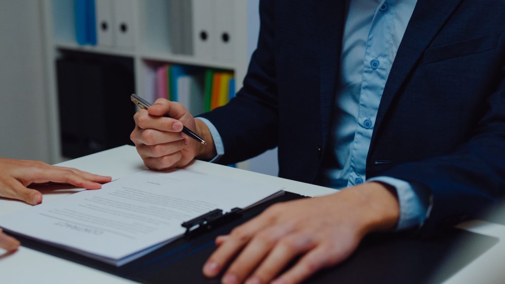 Closeup of young asian businessman mentor corporate leader manager counselor communicate with businesswoman and sign a contract at office night. businesspeople in workplace.